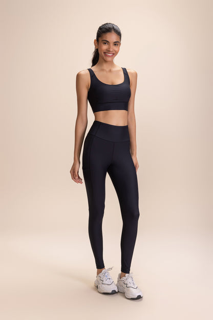 Woman wearing Legging 6 Pockets Speed and black sports bra, showcasing ergonomic design with six strategically located pockets for workout essentials.